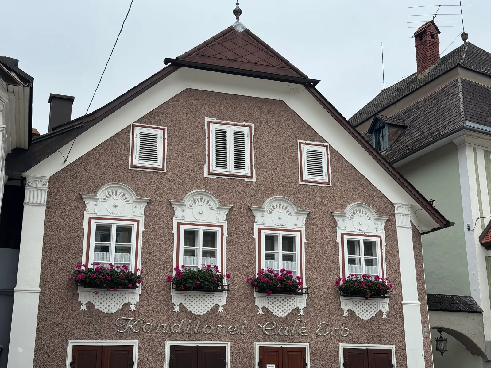 Fassade der Konditorei-Café Erb in Waidhofen an der Ybbs mit Stuckornamenten und Blumenkästen.