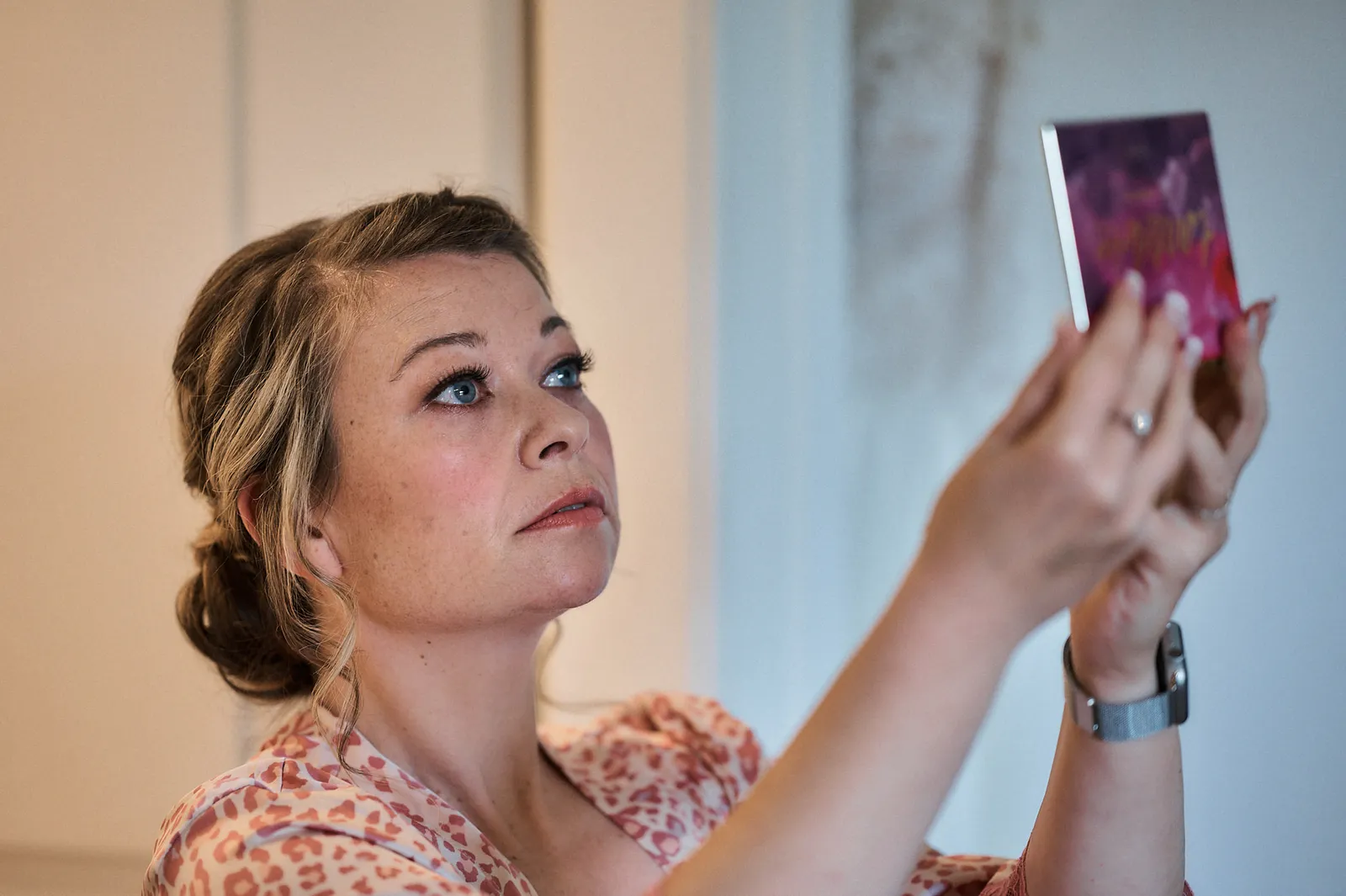 Die Braut kontrolliert Make-Up und Frisur