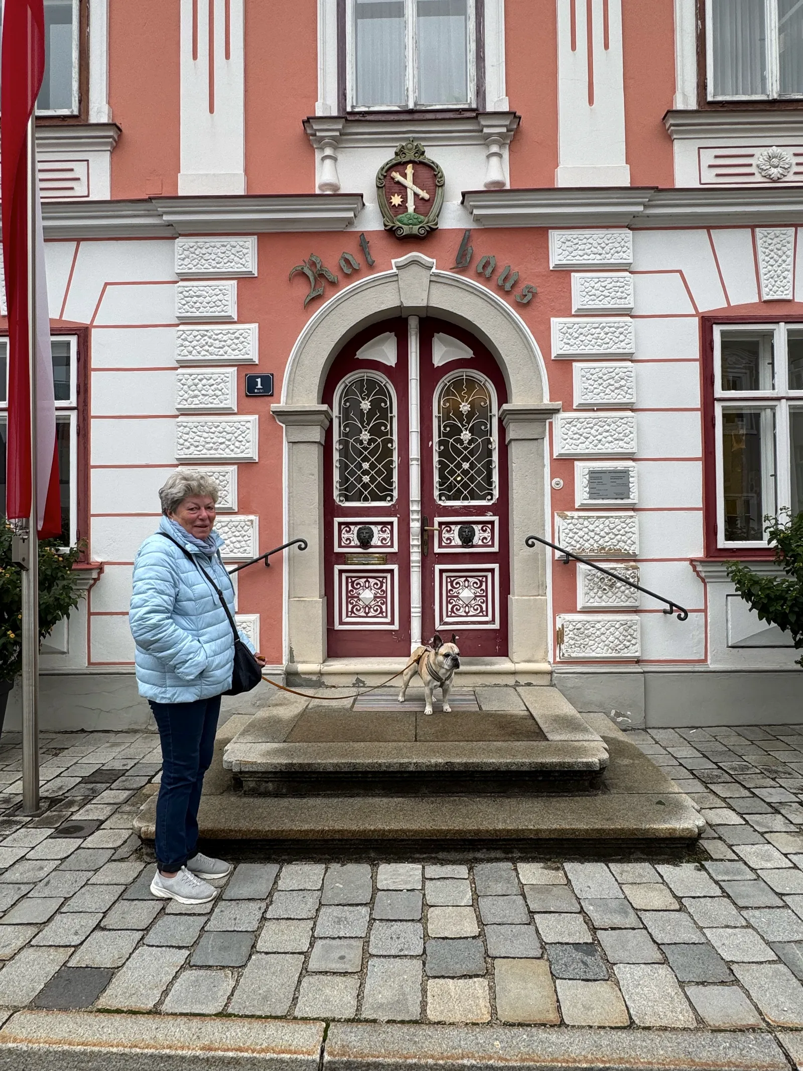 Eine Frau mit einer Französischen Bulldogge vor dem Rathaus in Ybbsitz.