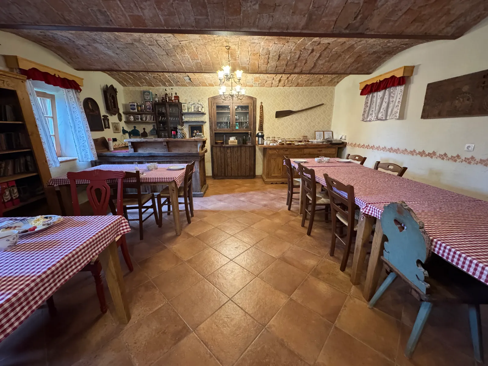 Frühstücksraum im Lavender Hill Eco Resort mit rot-weiß karierten Tischdecken und Ziegelgewölbedecke.