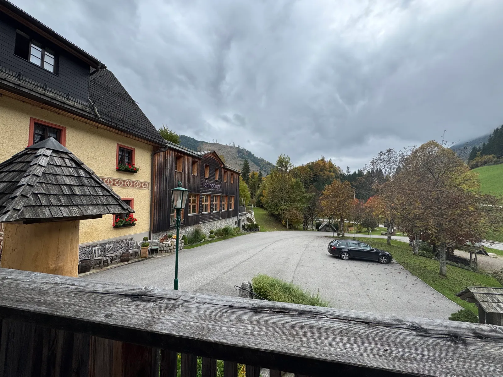 Das Hotel Fahrnberger mit Holzfassade und Parkplatz vor herbstlicher Bergkulisse.