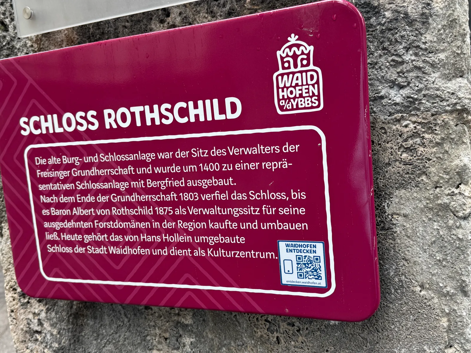 Informationstafel zu Schloss Rothschild in Waidhofen an der Ybbs an einer Steinmauer.