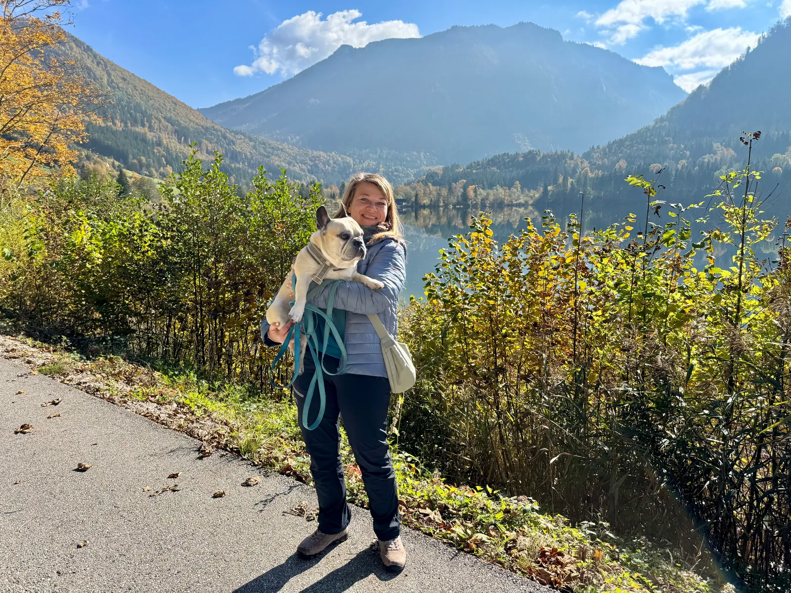 Babsi hält Murphy auf dem Arm am Lunzer See mit Bergen im Hintergrund.