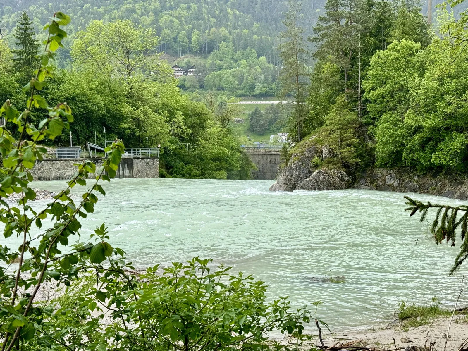Türkisfarbener Fluss mit Wehr und bewaldeten Hängen bei la LUNA delle MONTAGNE.