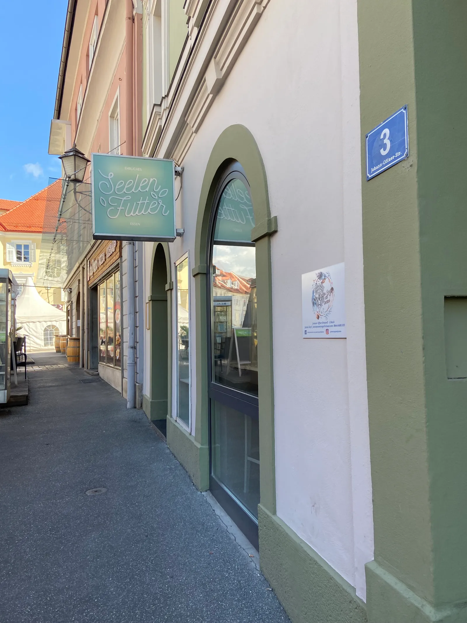 Außenansicht des Seelenfutter in Wolfsberg mit dem Schild über dem Bogeneingang.