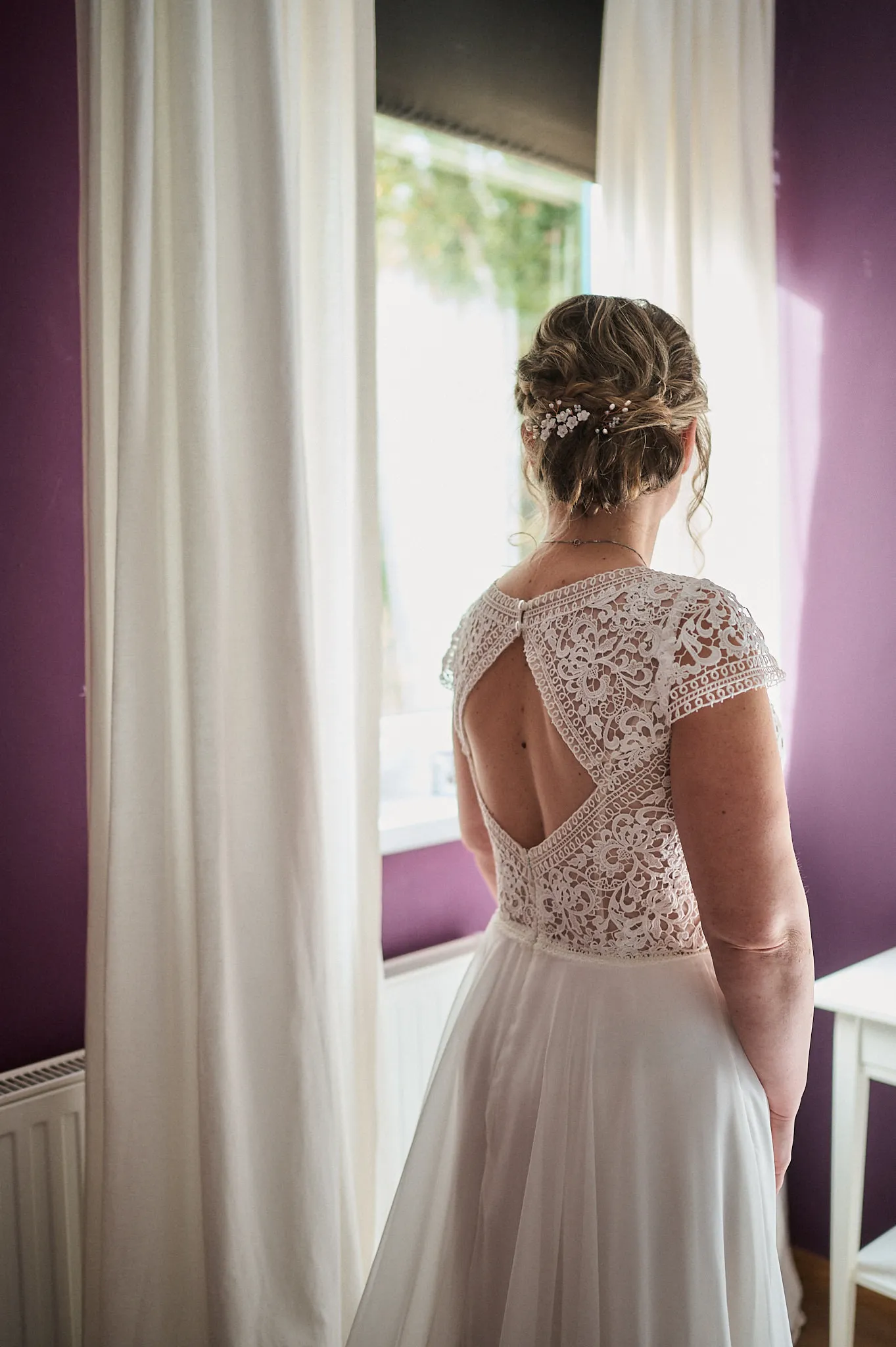 Babsi's Rückenansicht, Haare geflochten und mit Schmuck versehen, schicker Rückenausschnitt des Brautkleides