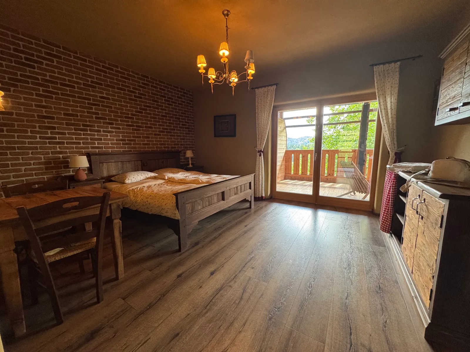 Schlafzimmer im Lavender Hill Eco Resort mit Doppelbett, Ziegelwand und Balkon mit Waldblick.