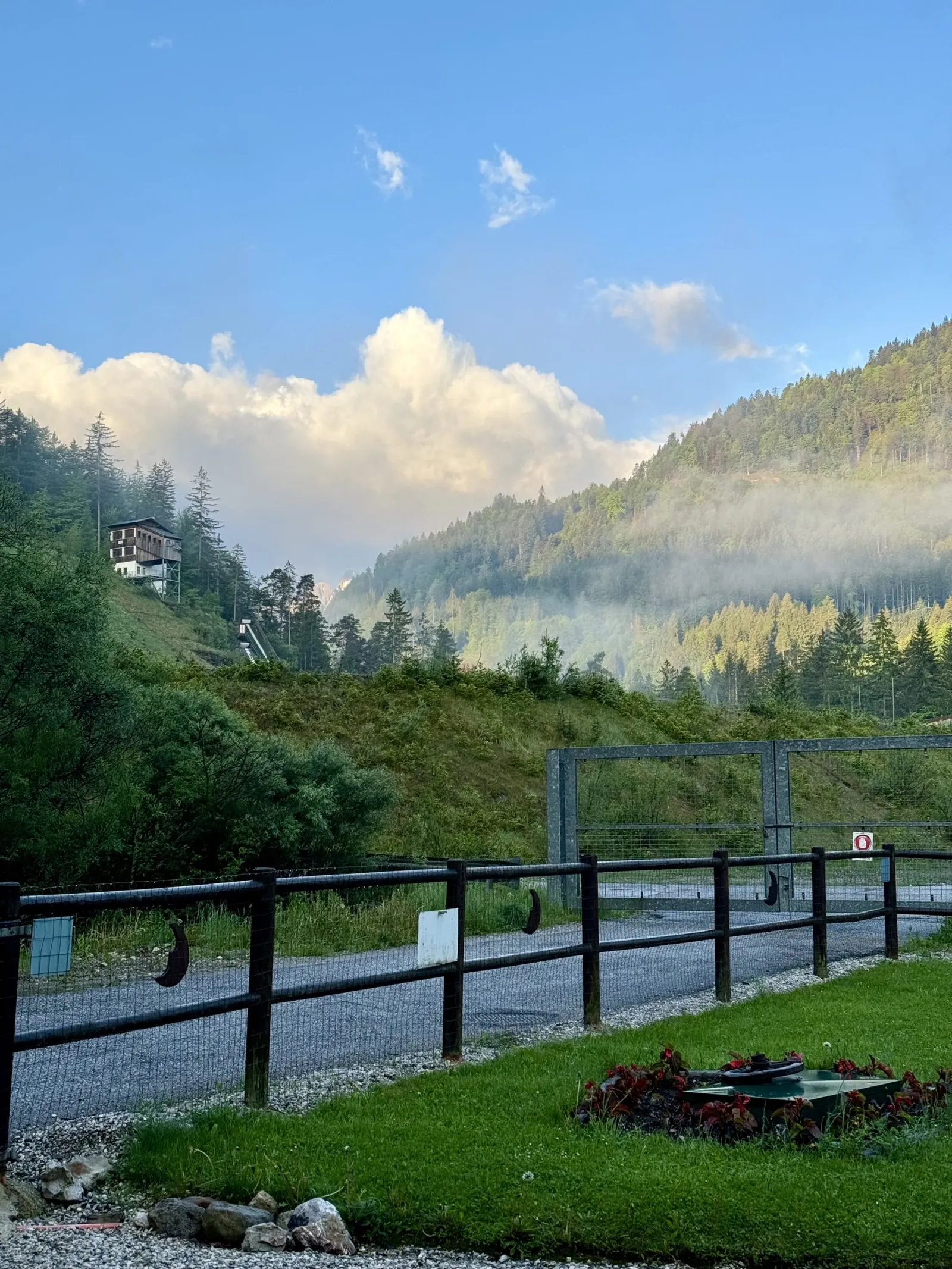 Morgenstimmung mit Blick auf bewaldete Berge im Nebel vom Unterkunftsgelände.